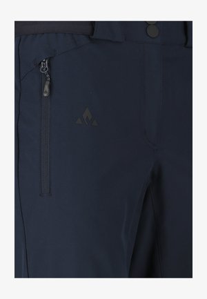 Dunkelblaue Hose mit Reißverschlusstasche an der Seite und kleinem dreieckigem Logo in der Nähe der Tasche am Oberschenkel.
