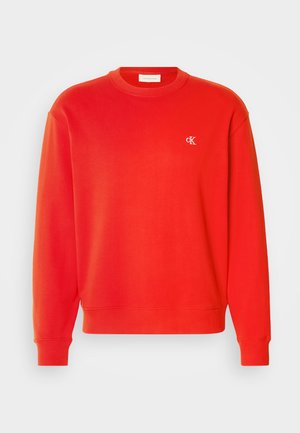 Roter Baumwollpullover mit gerippten Bündchen und Saum sowie einem kleinen gestickten Logo auf der linken Brust. Glatte Textur, klassisches Rundhalsdesign.