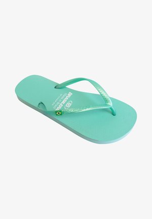 Chanclas de goma turquesa con suela texturizada y doble correa. Presenta un logo en relieve y un detalle de la bandera brasileña en la suela.