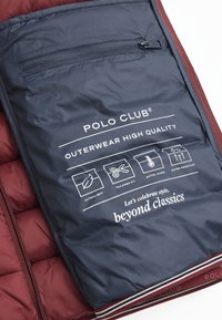 Prenda exterior color burdeos con interior azul marino. Presenta un bolsillo con cremallera, texto en blanco e iconos que indican características: ultraligero, corte ajustado, cálido, resistente al agua.