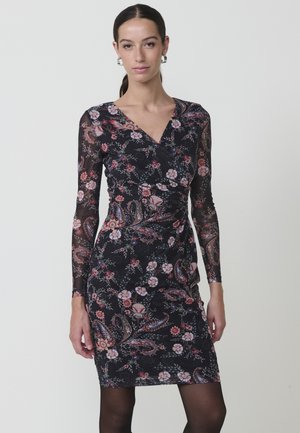 Vestido negro de manga larga con patrones florales y de paisley, con un escote en V profundo y tejido texturizado. Silueta ajustada.