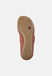 Leder-Schuh mit einer camel-farbenen Sohle, die eine strukturierte Kante aufweist und ein Design bietet, das Flexibilität ermöglicht. Der Absatz ist leicht erhöht.