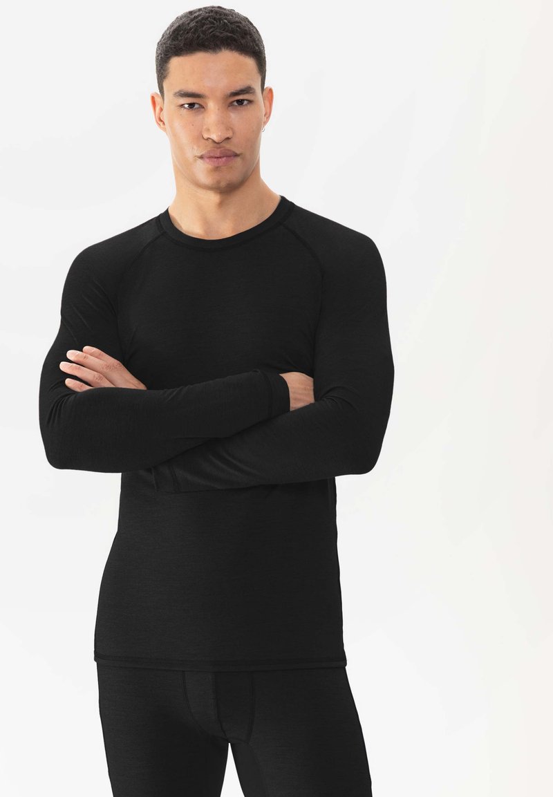 Haut thermique noir à manches longues avec un col rond et des poignets côtelés, présentant une coupe ajustée et une texture lisse.