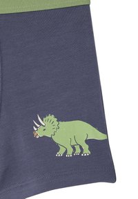 Navy blue shorts with a green waistband, featuring a printed green triceratops design on the lower leg. Smooth, cotton-like texture.