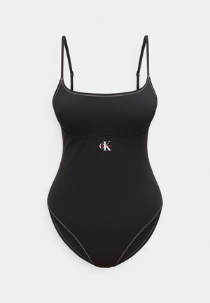 Maillot de bain une pièce noir avec fines bretelles réglables et coutures blanches, arborant un petit logo Calvin Klein au centre devant.