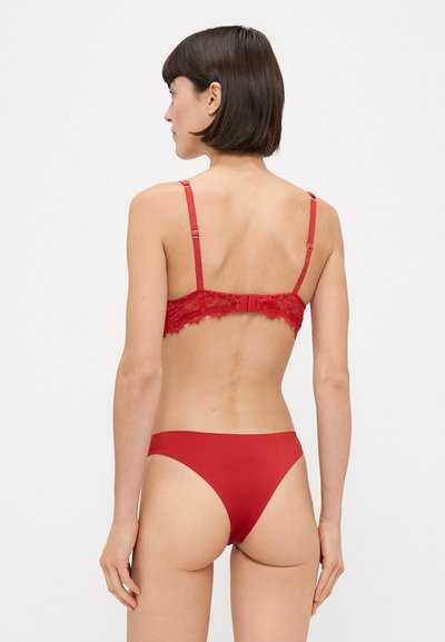 Sutien roșu din dantelă cu bretele ajustabile și închidere cu cârlig, asortat cu un fund de bikini roșu. Textură netedă și design cu acoperire minimă.