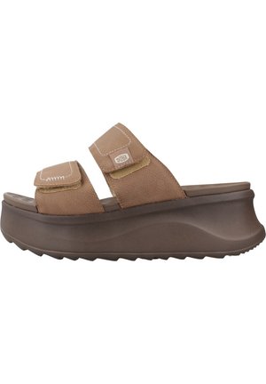 Sandale marron à enfiler avec deux brides réglables et une semelle plateforme épaisse, arborant le logo « Hey Dude » sur la bride supérieure.