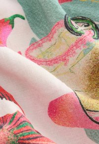 Bomuldsstof med et livligt blomstermønster i pink, grønne og gule nuancer. Teksturen fremstår blød og let krøllet.