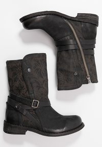 Bottines noires avec une tige en tissu texturé présentant un motif floral. Accents en cuir et fermeture éclair latérale pour plus de fonctionnalité.