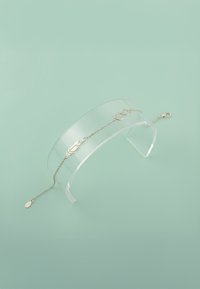 Guldtonad armband med ett blad- och oändlighetssymboldesign, med en känslig kedja, hummerlås och en tåra charm.