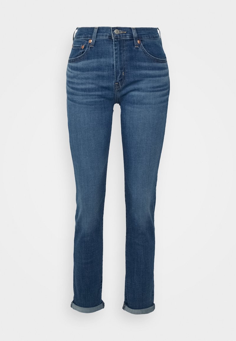 Dark blue denim jeans with a slim fit, high waist, rolled cuffs, and subtle fading. Features button closure and front pockets.