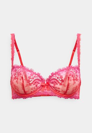 Różowy biustonosz z koronką, przezroczystymi miseczkami, kokardką na środku i regulowanymi ramiączkami. Całość zdobiona kwiatowym wzorem. Miękka w dotyku tkanina.