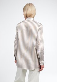 Camicia a righe button-up in cotone beige e bianco; presenta maniche lunghe, orlo arrotondato e polsini con bottone singolo. Tessuto liscio e leggero.