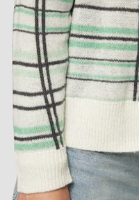 Leichter Strickpullover in Creme mit schwarz-grünem Streifenmuster. Verfügt über einen gerippten Saum und Ärmelbündchen, weiche Textur und lässiges Design.