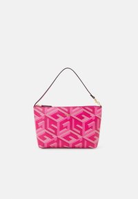Roze schoudertas met geometrische witte patronen, gouden "GUESS" logo en korte zwarte band met gouden sluiting op een witte achtergrond.