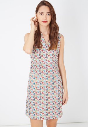 Vestido sin mangas con un patrón de estrellas multicolores sobre un fondo claro, con un diseño de escote en V profundo y una silueta ligeramente acampanada.