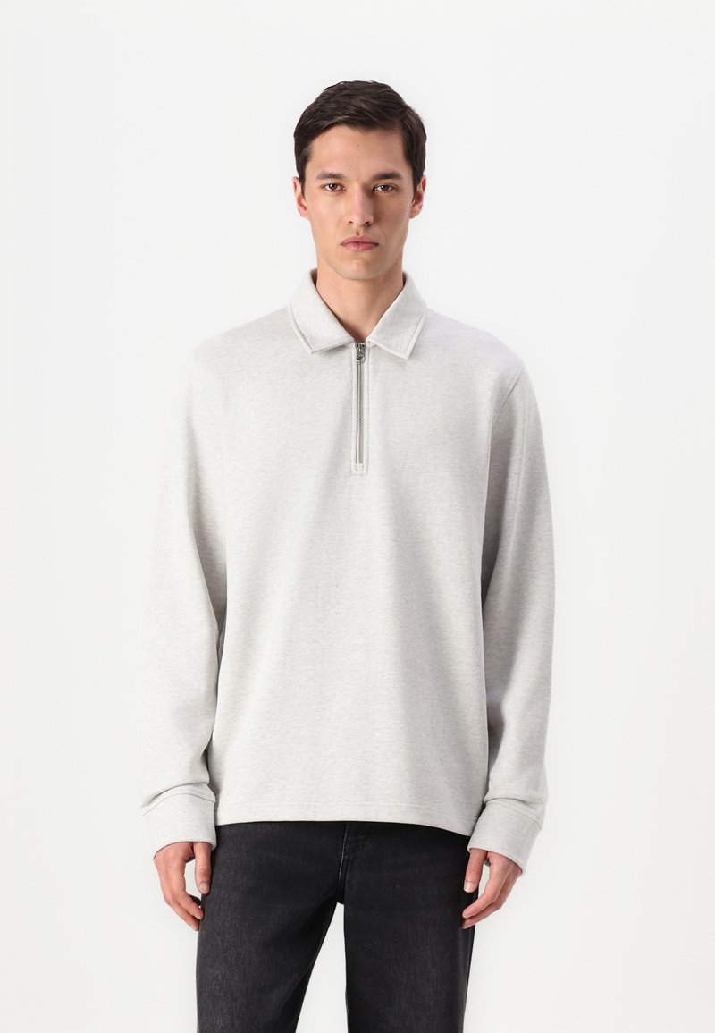 Light gray zip-up pullover with a collar, made from textured fabric, featuring long sleeves and a relaxed fit. Simple design with no patterns.