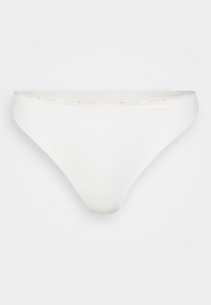White cotton thong with a smooth texture. Features a thin waistband with "TOMMY HILFIGER" in soft pink lettering. Minimalist design.