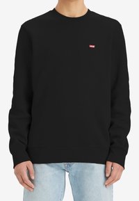 Sudadera negra de mezcla de algodón, con cuello redondo, mangas largas y un pequeño logo rojo de Levi's en el pecho. Corte clásico.