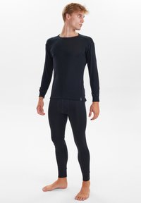 Black long-sleeve thermal top and matching leggings. Soft fabric, fitted design, with ribbed cuffs, and no visible branding or patterns.