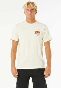 Cremefarbiges Baumwoll-T-Shirt mit rundem Ausschnitt, kurzen Ärmeln und einer mehrfarbigen Sonnenuntergang-Grafik auf der linken Brust.