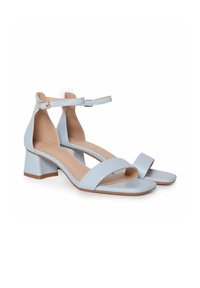 Sandalias de tacón azul claro con un diseño de punta cuadrada, correa alrededor del tobillo y tacón cuadrado. Fabricadas en material suave con una plantilla beige.