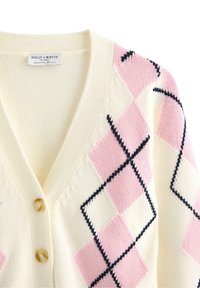 Krémový kardigan se růžovým a černým kosočtvercovým vzorem, s výstřihem do V, třemi knoflíky a texturovanou pleteninou. Viditelná značka.