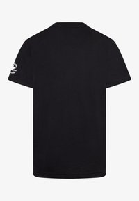 Camiseta de algodón negra de manga corta, con cuello redondo y un detalle de logo en la manga izquierda. Textura suave y corte regular.