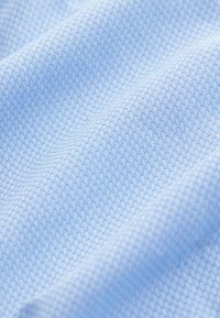 Tissu bleu clair avec un motif tissé texturé, présentant un design en grille. Aspect lisse avec une profondeur et une dimension subtiles.