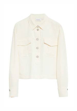 Cremefarbene kurze Jacke mit langen Ärmeln, silbernen runden Knöpfen vorne und zwei Brusttaschen mit Klappen.