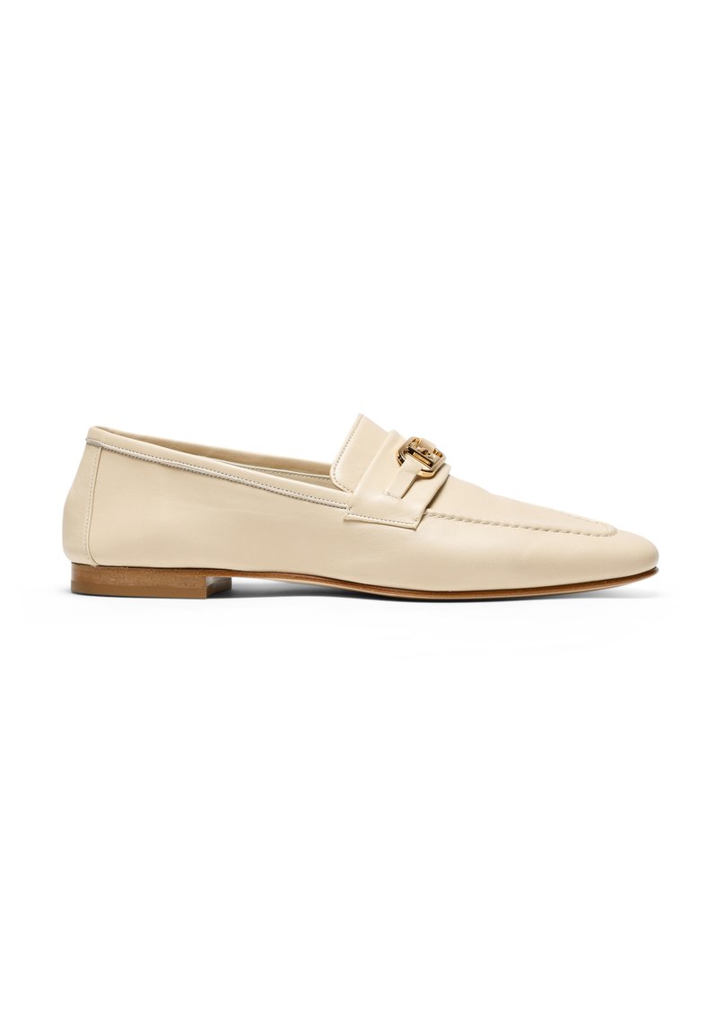 Mocassins en cuir beige avec un bout rond, un talon en bois plat, et un accent de boucle dorée à l'avant. Surface lisse et coutures minimales.