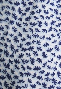 Modrý abstraktní květinový vzor vytištěný na látce s modrou tkaninou.