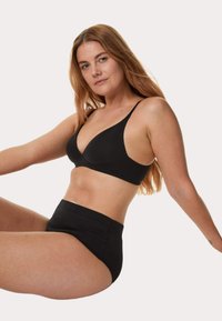 Zwart lingerieset met een naadloze bralette en hooggetailleerde slips van een zachte, rekbare stof. Eenvoudig ontwerp met verstelbare bandjes.
