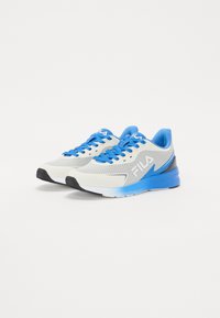 Baskets de sport blanches et bleues avec une tige en maille, des lacets bleus, une semelle extérieure en caoutchouc noir texturé et un accent de logo sur le côté.