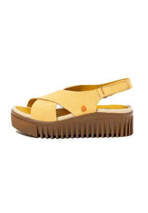 Sandale plateforme en daim jaune avec semelle épaisse marron à rainures et bride arrière ajustable avec fermeture Velcro.