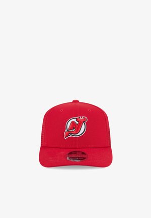 Red snapback cap with New Jersey Devils logo featuring a stylized "NJ" with devil horns and tail on the front panel.