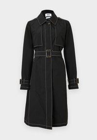 Gabardina negra hasta la rodilla con costuras contrastantes en blanco, cintura con cinturón, solapa con botones, hombreras y correas en los puños.