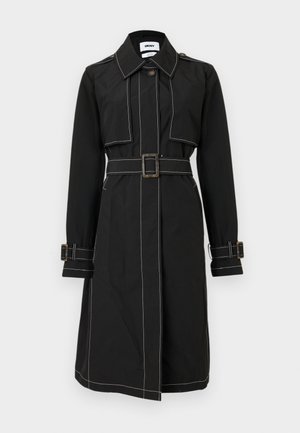 Melns treniņmētelis līdz ceļiem ar baltām kontrastējošām šuvēm, jostiņu viduklī, aizpogājamu atloku, plecu uzplečiem un aproču siksnām.