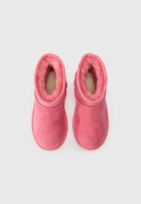 Bottines en daim rose avec une doublure douce et duveteuse et un bout arrondi. Dotées d'un design cousu et d'une semelle légèrement surélevée pour plus de confort.