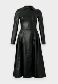 Μαύρο δερμάτινο φόρεμα με εφαρμοστό μπούστο, μακρυά μανίκια και φούστα που ανοίγει. Διαθέτει φερμουάρ μπροστά και δύο πλαϊνές τσέπες με φερμουάρ.