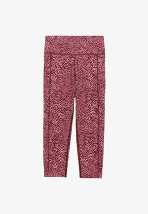 Haut de sport rose avec un design dos nageur associé à un legging capri arborant un imprimé léopard rose et noir. Des chaussures de sport noires complètent la tenue.