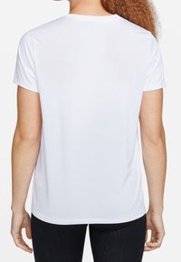 Vit kortärmad T-shirt, mjukt tyg med rund halsringning. Baksidan har en rak fåll och en avslappnad passform.