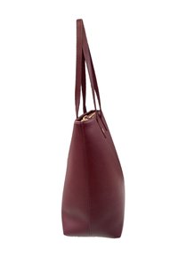 Borsa a tote in pelle bordeaux con doppi manici e chiusura con zip dorata, mostrata in vista laterale su sfondo bianco.