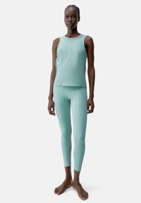 Mintgroen activewear set met een mouwloze top en strakke leggings. Gladde textuur, minimalistisch design, geen zichtbare logo's of hardware.