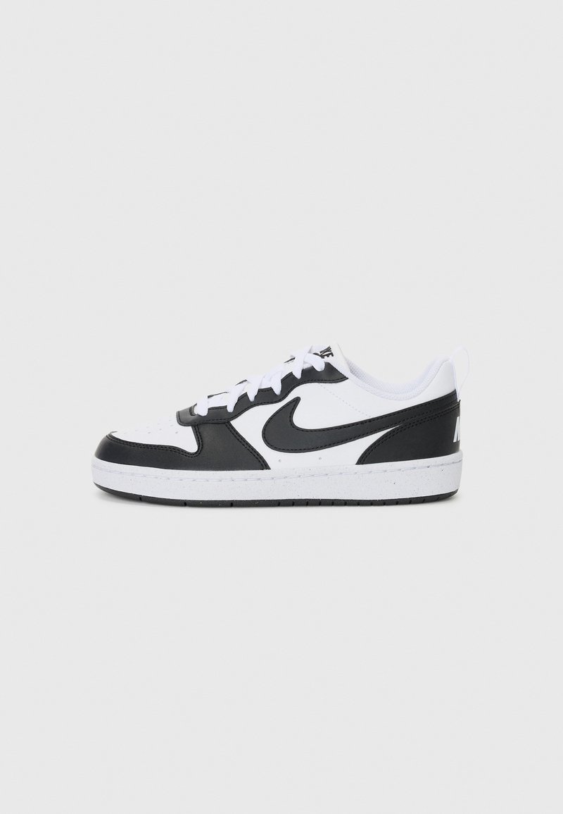 Črno-bela sneakers čeljust z usnjeno zgornjico, perforiranim prstom, belimi vezalkami in kontrastnim črnim logotipom. Teksturirana gumijasta podplata.