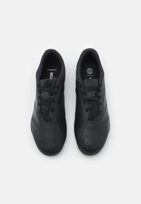 Czarne buty sportowe wykonane z teksturowanego materiału syntetycznego, o eleganckim designie, okrągłym nosku i płaskich sznurowadłach. Charakteryzują się subtelnym wzorem perforacji.