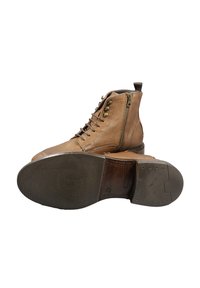 Stivaletti alla caviglia in pelle marrone con finitura testurizzata, design con lacci, cerniera laterale e punta tonda. Suole in gomma con battistrada a motivo.