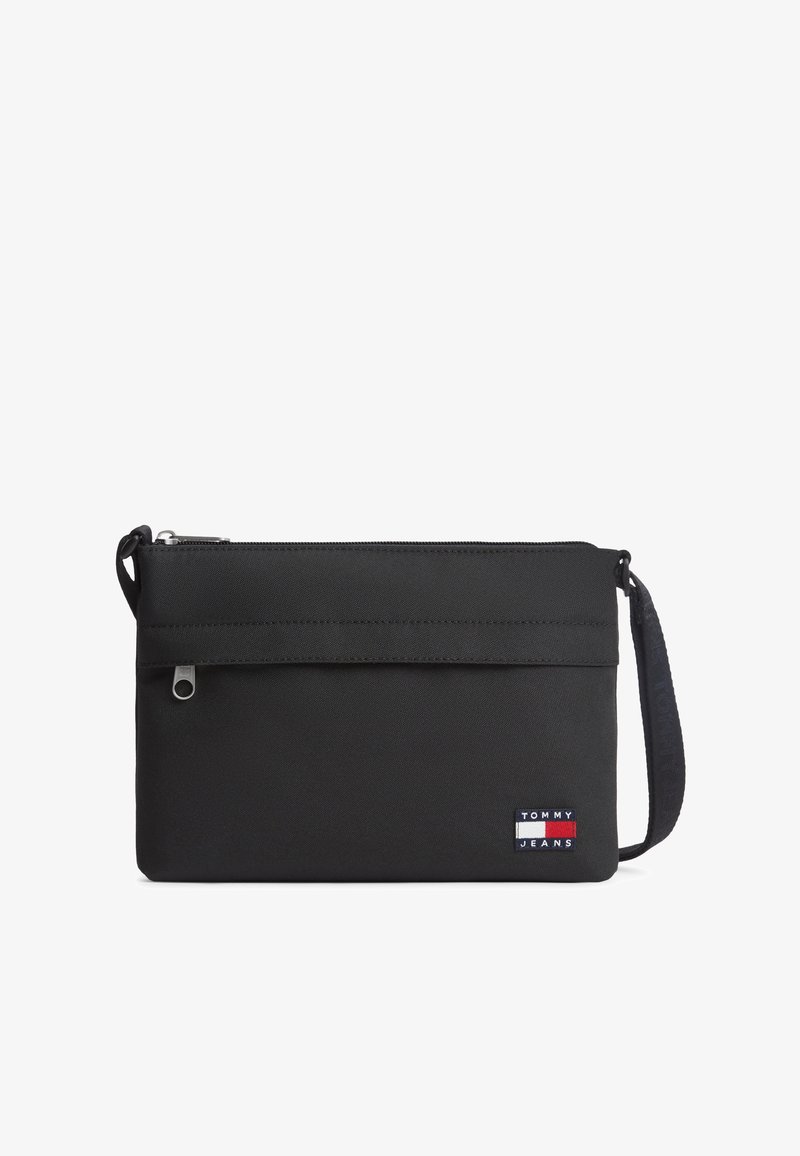 Μαύρο ορθογώνιο τσαντάκι crossbody με μπροστινή τσεπούλα με φερμουάρ, ρυθμιζόμενο ιμάντα και ετικέτα με το λογότυπο Tommy Jeans στην κάτω δεξιά γωνία.