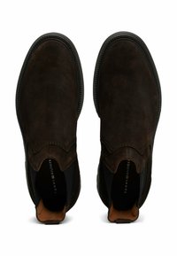 Scarpe slip-on in suede marrone con pannelli elastici laterali, cuciture decorative, punta arrotondata liscia e fodera interna imbottita.
