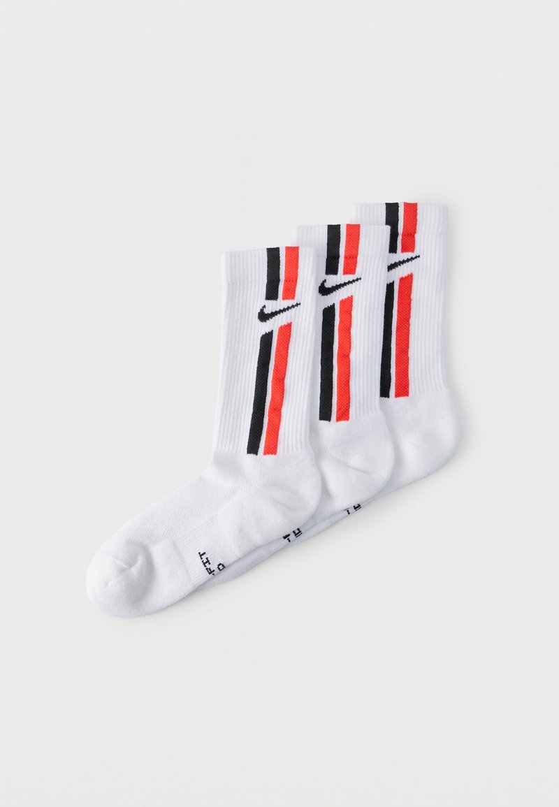 Trois chaussettes montantes blanches Nike avec des rayures verticales noires et rouges et des logos Nike swoosh noirs de chaque côté.